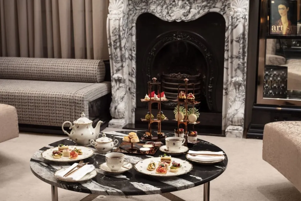 Sanasaryan Han The Library salonunda şömine önünde servis edilen zarif Afternoon Tea sunumu, tarihi atmosferde beş çayı keyfi