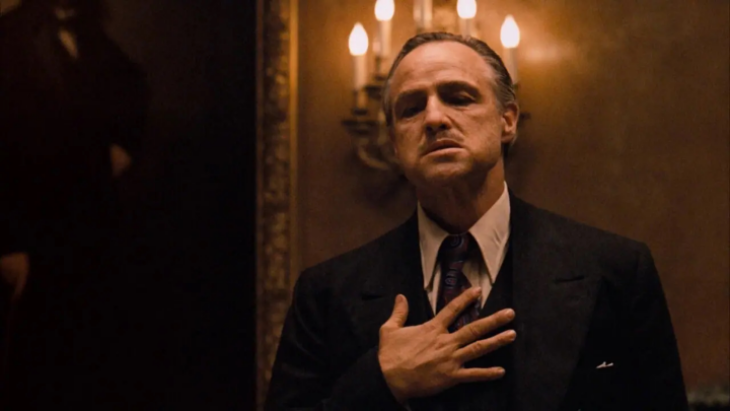 The Godfather filminden Marlon Brando'nun canlandırdığı ikonik baba figürü Vito Corleone, eli kalbinde düşünceli bir ifadeyle.
