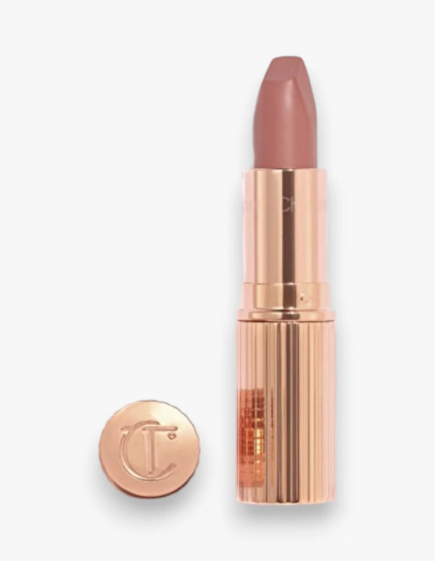 Charlotte Tilbury Matte Revolution serisinden Pillow Talk Medium rengi ruj, gül altın rengi yivli ambalajında dik dururken, üzerinde zarif bir CT logosu bulunan kapağı yanında beyaz bir zeminde sergileniyor.