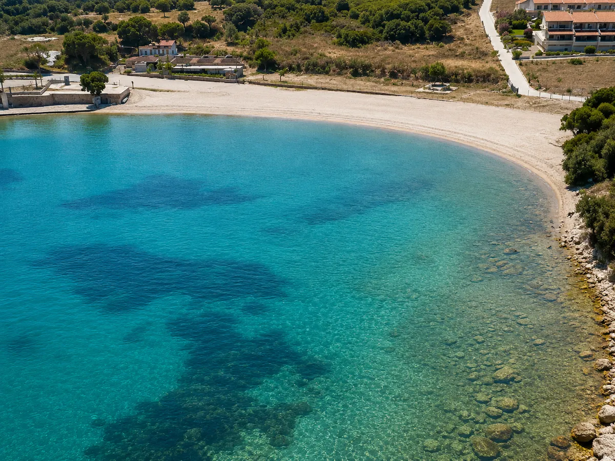 Havadan çekilmiş bu büyüleyici görüntüde, Çeşme Dalyan'daki Kocakarı Plajı'nın turkuaz rengi berrak sularıyla göz alıcı hilal şeklindeki kumlu sahili, çevresindeki yeşil tepeler, kıyıdaki binalar ve deniz dibindeki kayalıklar tüm detaylarıyla sergileniyor.