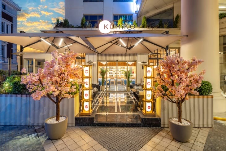 Kumiko Sushi & More restoranının Japon ahşap sanatı ve Sakura felsefesini yansıtan aydınlatılmış şık girişi, pembe kiraz çiçekleri ve geleneksel motifli fenerlerle süslenmiş olup, İstanbul'un en popüler sushi restoranları arasındaki yerini vurguluyor.