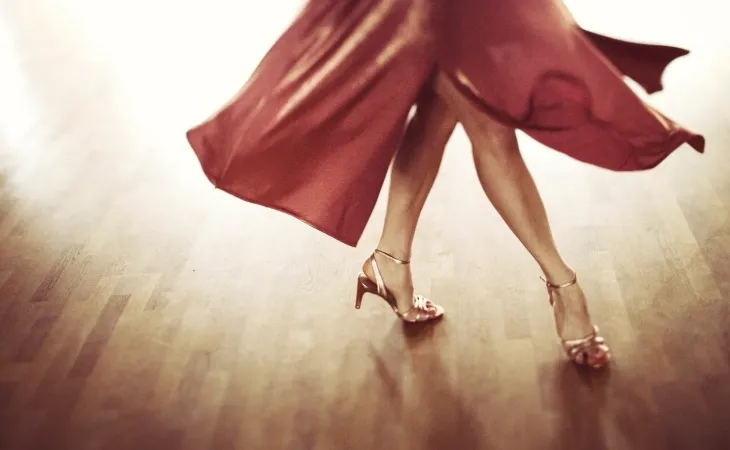 Kırmızı elbiseli bir dansçının salsa adımı; enerjik latin ritimleriyle yapılan kalori yaktıran salsa dansı.
