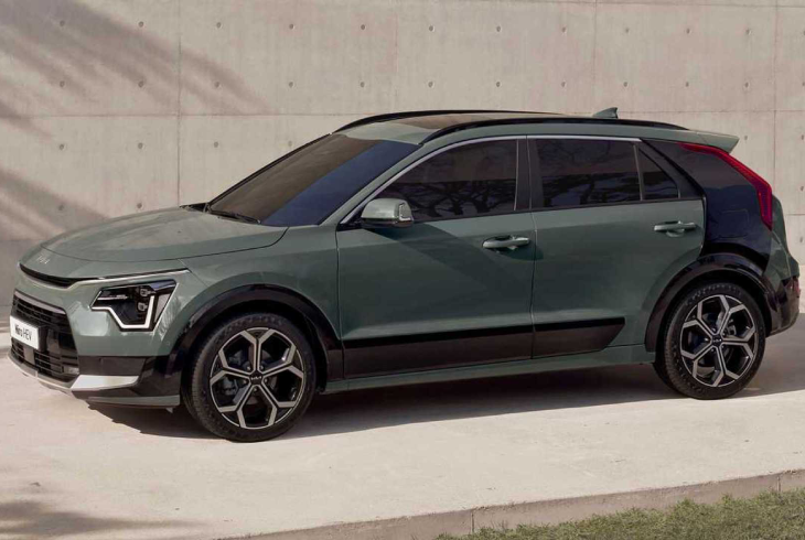 Yeşil Kia Niro EV elektrikli SUV, modern beton zemin önünde yan profilden sade ve güçlü tasarımıyla sergileniyor.