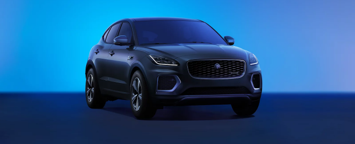 Siyah Jaguar E-Pace SUV, mavi tonlu stüdyo arka planında ön açıdan sportif ve şık tasarımıyla sergileniyor.