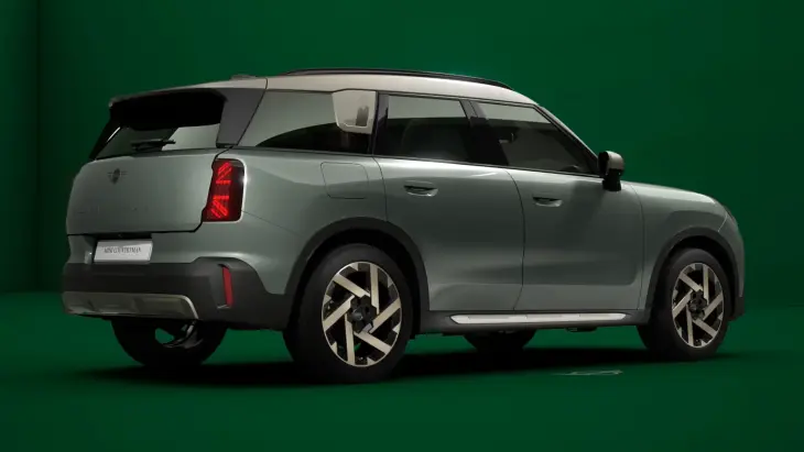 Gri MINI Countryman SUV, yeşil stüdyo arka planında arka üç çeyrek açıdan modern ve kompakt tasarımıyla sergileniyor.