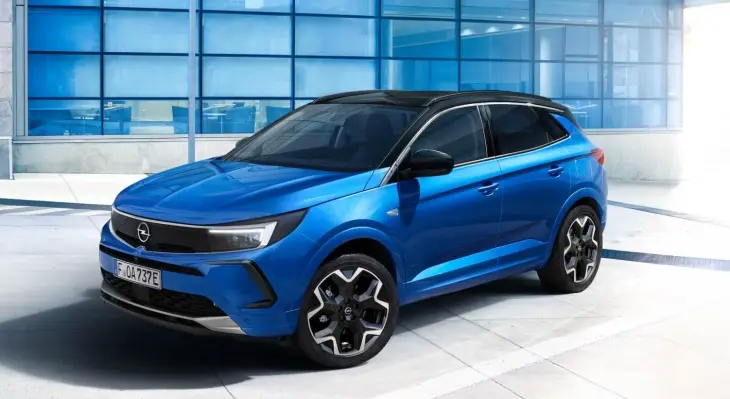 Mavi Opel Grandland SUV, modern cam cepheli bina önünde şık ve dinamik tasarımıyla sergileniyor.