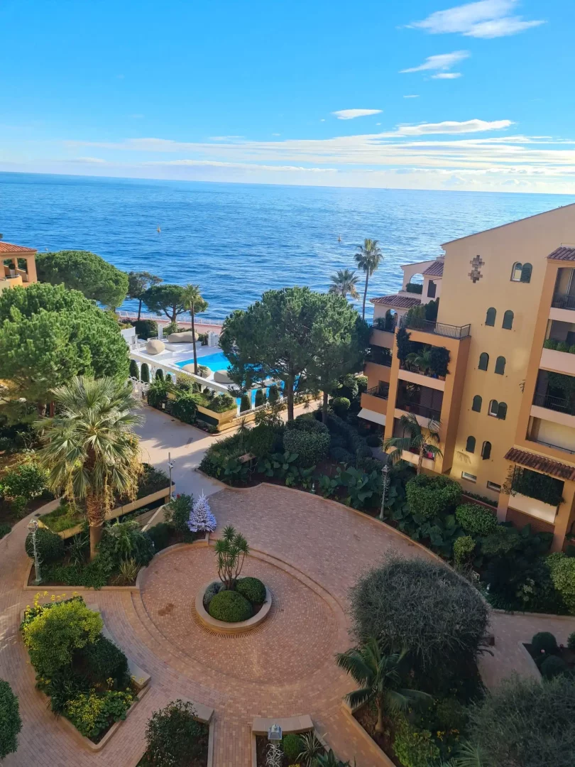 Monte Carlo'daki Columbus Otel'in üst katlarından çekilmiş bu geniş açılı fotoğrafta, yemyeşil bahçeler, şık havuz alanı ve masmavi Akdeniz bir araya gelerek lüks bir tatil atmosferi sunuyor.