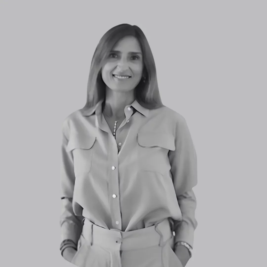 Uzun saçları, gülümseyen yüzü ve şık duruşuyla Barbara Del Neri, iki göğüs cepli açık renk yakalı gömleği, elleri ceplerinde durduğu uyumlu pantolonu, boynundaki kolyesi ve bilezikleriyle düz gri bir arka plan önünde Dr. Vranjes Firenze konulu makale için poz veriyor.