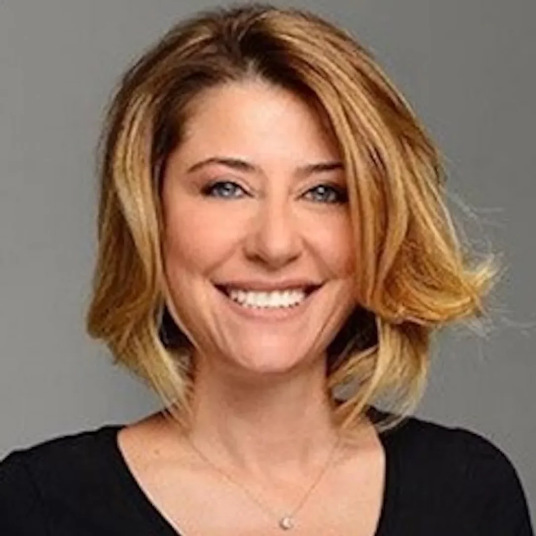 Elif Dağdeviren, sarı omuz hizası saçları ve mavi gözleriyle neşeli bir şekilde gülümserken, siyah bir tişört ve zarif bir kolye takmış, profesyonel bir gazeteci olarak bu yakın planda poz veriyor.