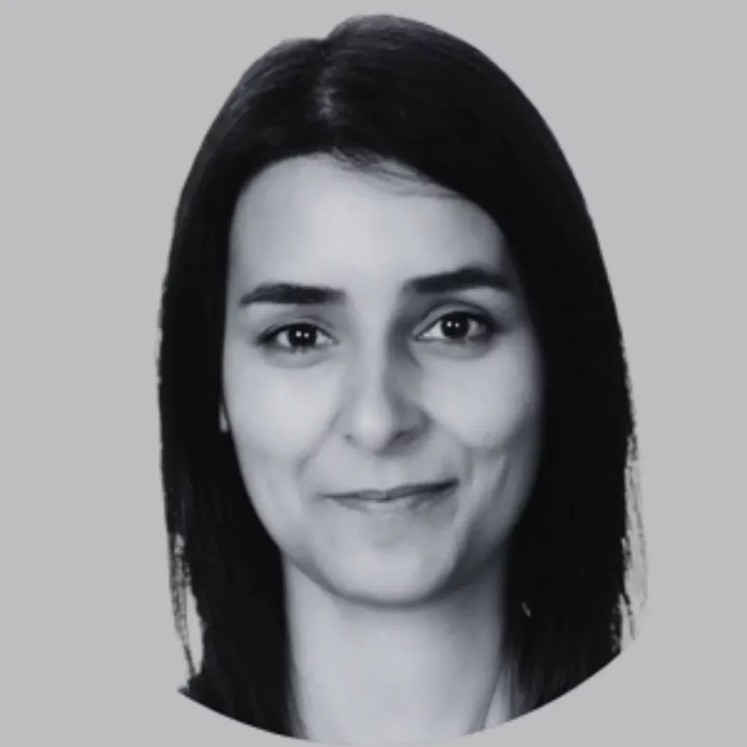 Siyah beyaz çekilmiş, düz gri bir arka plan önünde, koyu renk saçları omuzlarına dökülen, doğrudan kameraya bakarak nazikçe gülümseyen bir kadının profesyonel portresi, makalede yer alan Burcu Merve Ay'ı betimlemektedir.