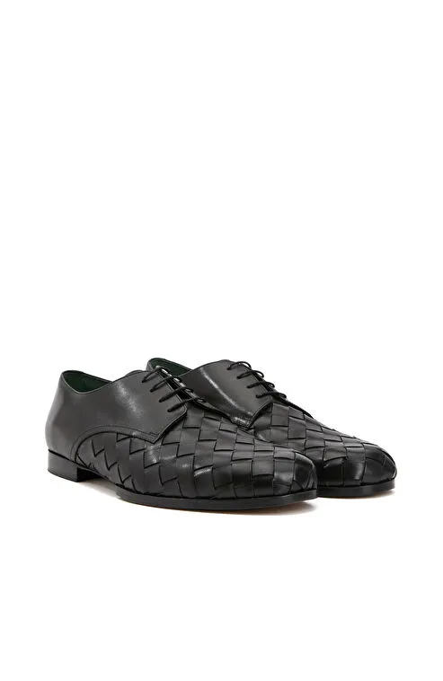 El işçiliğiyle hazırlanmış siyah örgü deri ayakkabı, klasik stilin dışına çıkan ama zarafetinden ödün vermeyen damatlar için etkileyici bir alternatif sunuyor.