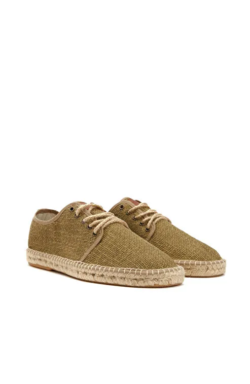 Doğal dokulu keten kumaşı ve el işçiliğini andıran kalın ip dikiş detaylarıyla, bohem sahil düğünleri için ideal espadril-sneaker hibriti bir model.