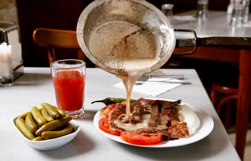 Bursa Uludağ Kebapçısı’nda tereyağı dökülen İskender kebap, yanında turşu ve şalgam suyu ile geleneksel sunum