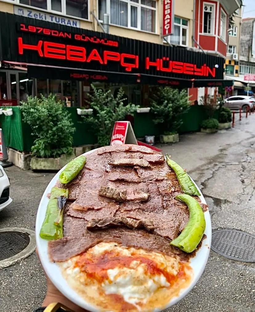 Kebapçı Hüseyin Usta’da tereyağlı İskender kebap, yoğurt ve közlenmiş biber ile servis edilmiş tabak