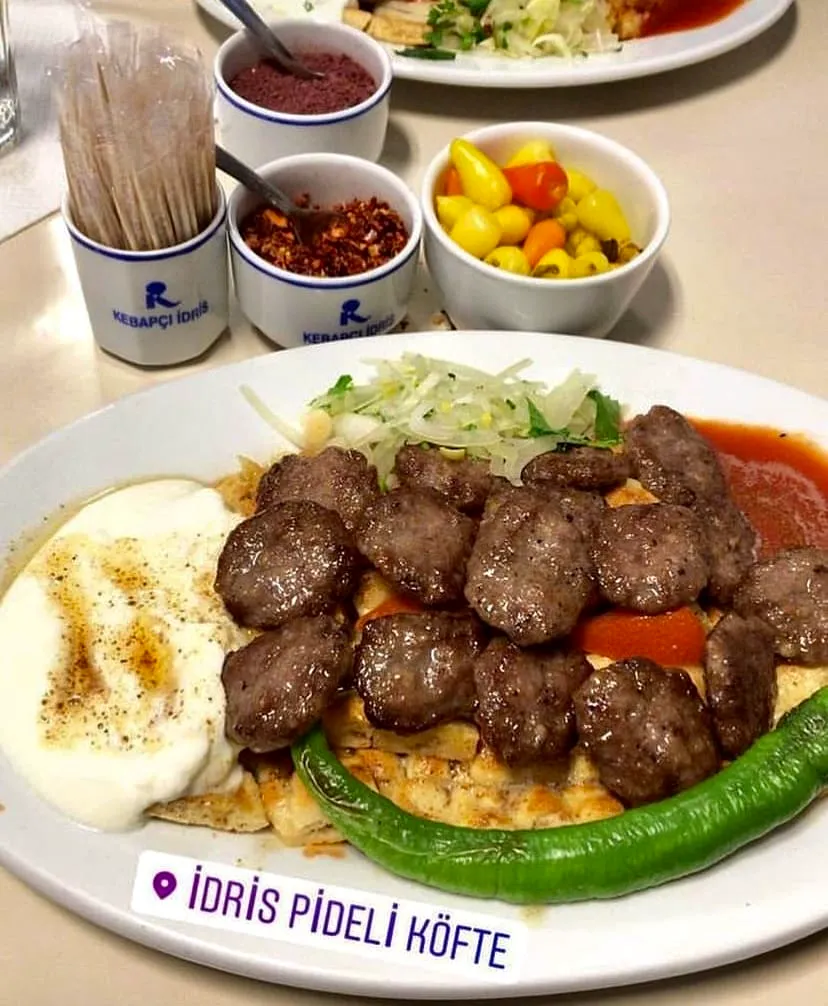 Bursa Kebapçı İdris’te servis edilen geleneksel pideli köfte, yoğurt ve közlenmiş biber eşliğinde