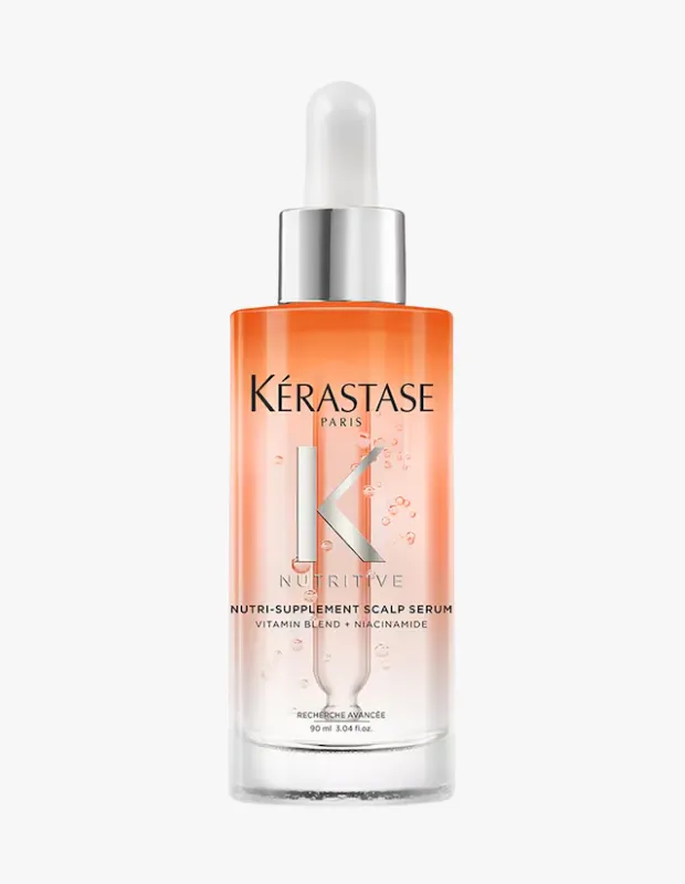 Beyaz arka planda, Kérastase markasına ait, üst kısmı şeffaf turuncu renkte başlayıp alta doğru şeffaflaşan, üzerinde Nutri-Supplement Scalp Serum Vitamin Blend + Niacinamide yazıları bulunan, damlalıklı kapaklı, 90 ml'lik bir saç derisi serumu şişesi net bir şekilde sergileniyor.