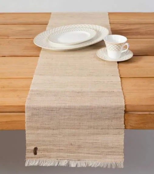 Bohem masa düzenlemelerine sade şıklık getiren doğal tonlarda keten masa örtüsü ve zarif seramik tabak, fincan ve çay tabağı.