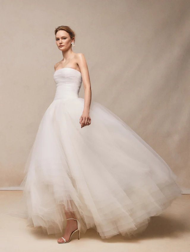 Oscar de la Renta 2026 koleksiyonundan, katmanlı tül etekli ve straplez yaka minimalist gelinlik modeli.