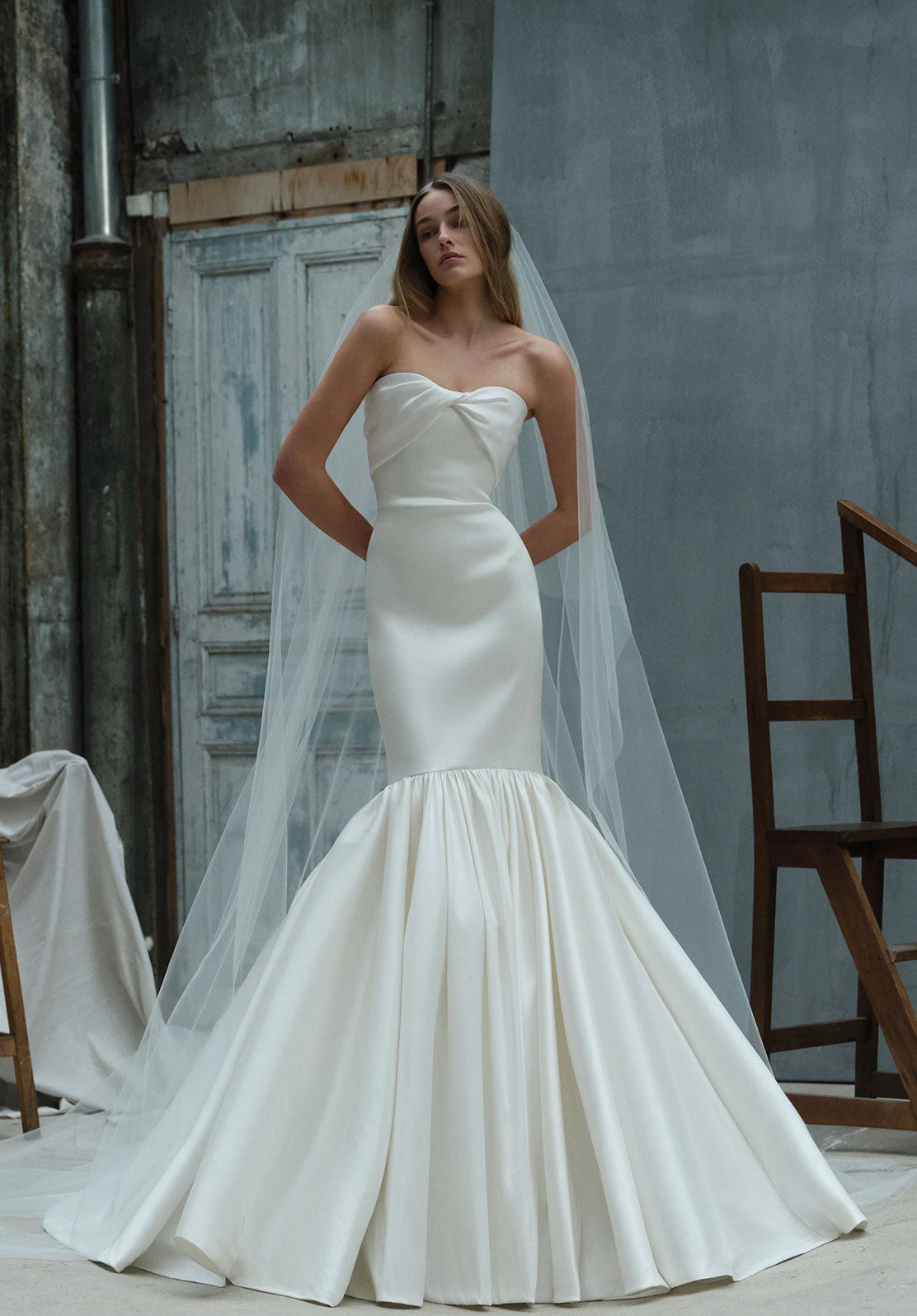 Straplez üstlü, balık formunda minimal Elie Saab gelinlik; sade saten kumaş ve uzun duvakla modern, zarif bir bridal siluet.