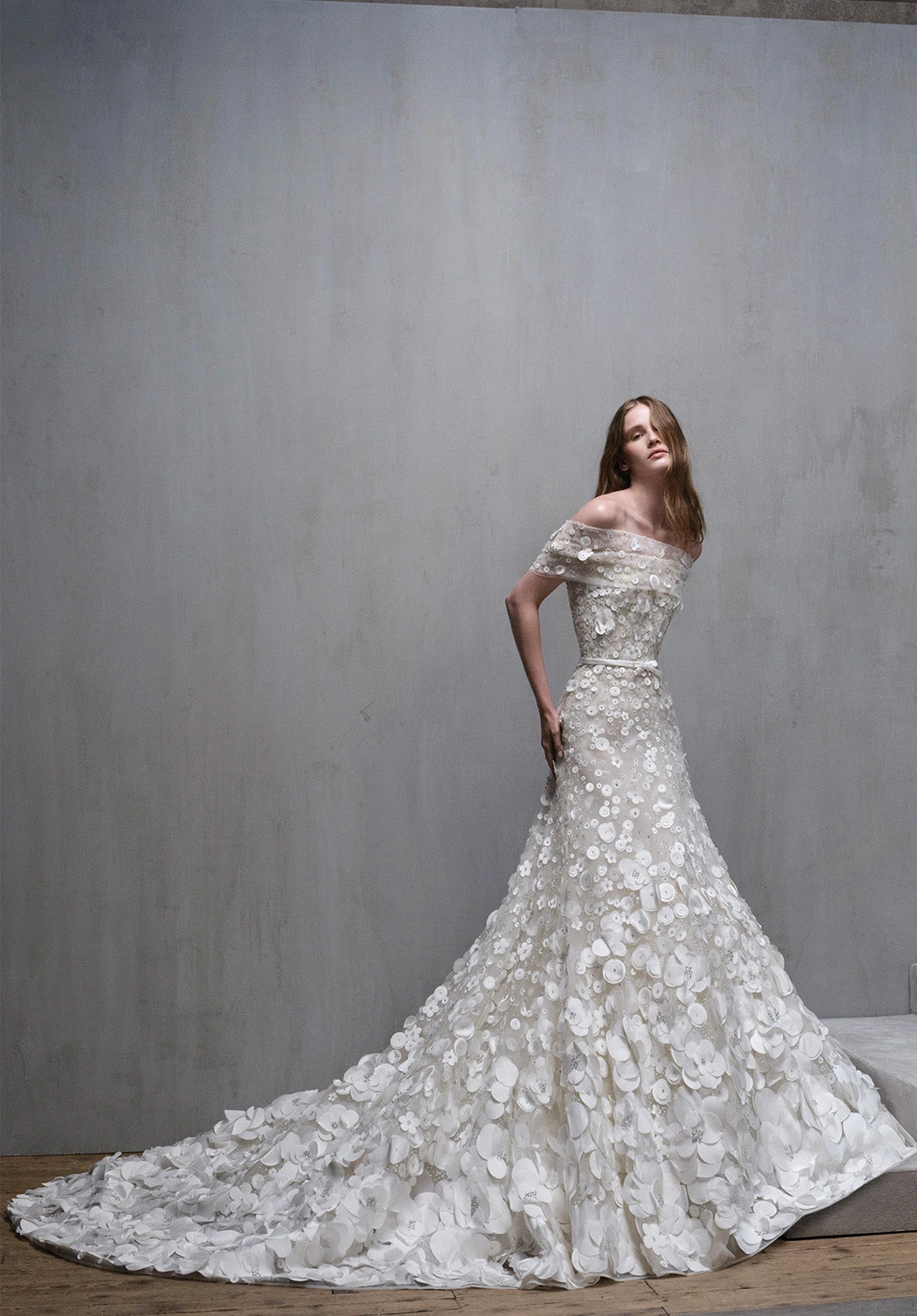 Omuzları açık, üç boyutlu çiçek aplikeli balık kesim Elie Saab gelinlik; romantik doku ve uzun kuyruk.