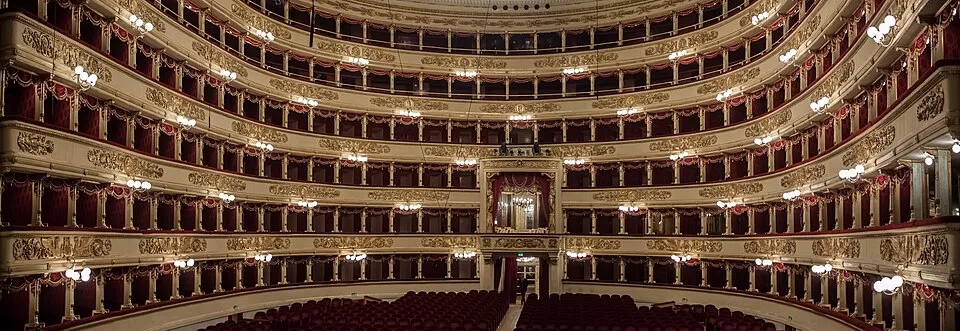 Milano'daki dünyaca ünlü Teatro alla Scala'nın içinden geniş bir görünüm sunan bu fotoğraf, altın varaklı bej rengi, kırmızı kadife kaplı ve her birinde ışıklar yanan loca ve balkon katları ile aşağıda boş duran yüzlerce kırmızı koltuğuyla tiyatronun tarihi ihtişamını ve sanatsal atmosferini gözler önüne seriyor.