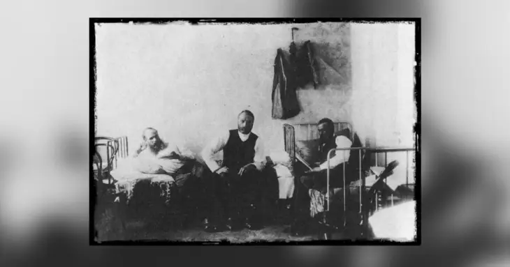 Dostoyevsky'nin hayatının ve bilinmeyen yönlerinin bir parçası olabilecek, siyah beyaz eski bir fotoğrafta, basit metal karyolaların bulunduğu sade bir odada, bir yatakta uzanan, bir diğeri kameraya bakan ve sonuncusu yatağında kitap okuyan üç erkek tasvir ediliyor.