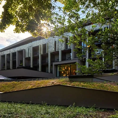 Alsace bölgesinde yer alan modern mimarili Voco Strasbourg Nord otel binası; geniş terasları ve çağdaş cephe tasarımıyla doğa içinde konumlanmış konaklama alanı.