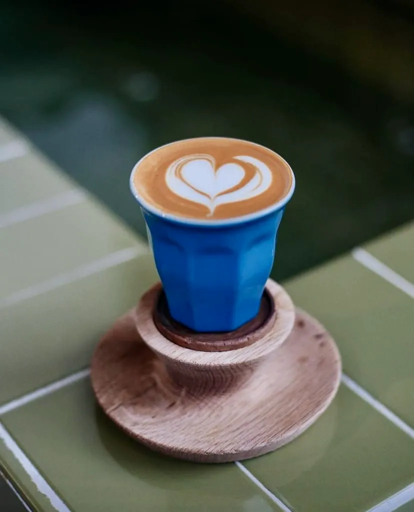 Mavi fincanda kalp desenli latte art ile servis edilen Cup of Joy kahvesi, Nişantaşı.