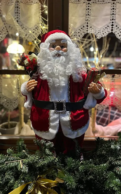 Kaysersberg’de Alsace Noel Pazarları atmosferinde yılbaşı süslemeleri arasında sergilenen Santa Claus (Noel Baba) figürü ve hediyelik dekorlar.