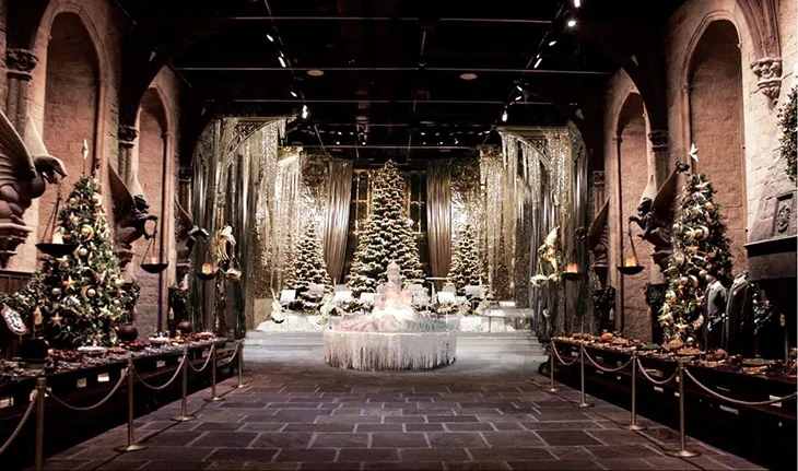 Harry Potter stüdyolarında kar temalı Hogwarts Büyük Salon dekorasyonu ve yılbaşı süslemeleriyle büyülü Noel atmosferi.