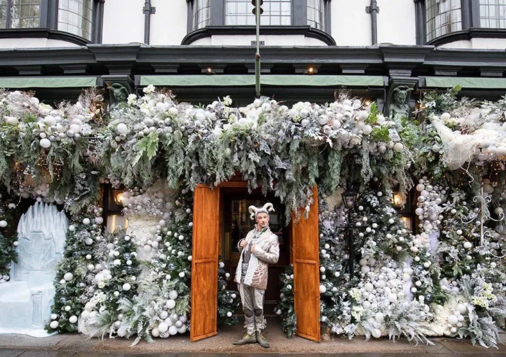 The Ivy Chelsea Garden restoranının kış temalı yılbaşı süslemeleri ve kostümlü karşılama görevlisiyle Londra’da büyülü Noel atmosferi.