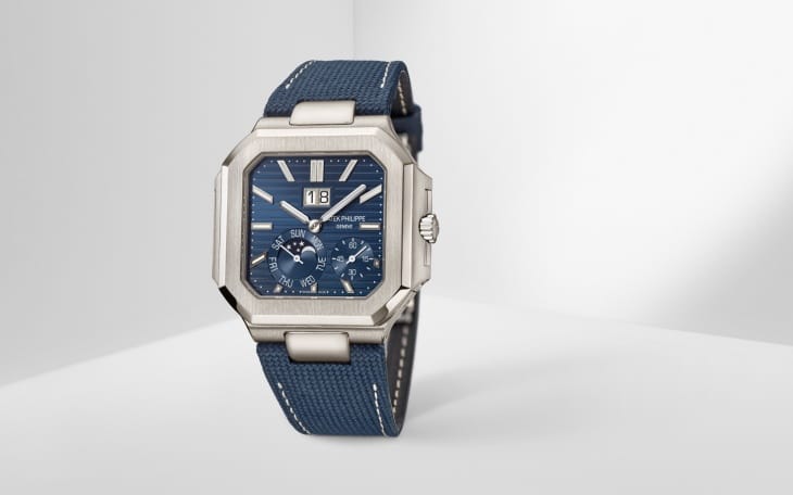 Patek Philippe Cubitus Koleksiyonu'ndan, sekizgen formda parlak metal kasası, koyu mavi yatay çizgili kadranında 12 yönündeki büyük tarih göstergesi (18), ay evresi, gün (Pazar) ve ay (Temmuz) komplikasyonlarını barındıran, beyaz dikişli lacivert kumaş kayışıyla öne çıkan bu model, markanın 25 yıl aradan sonra gelen yenilikçi yüzünü sergiliyor.