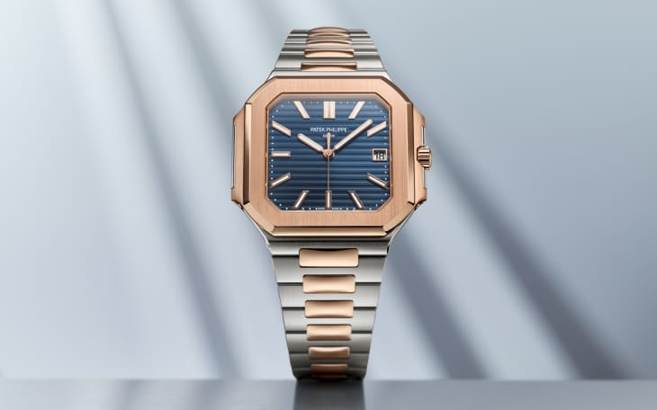 Patek Philippe Cubitus Koleksiyonu'ndan, çelik ve gül altının lüks uyumunu sergileyen, sekizgen gül altın kasaya, yatay çizgili lacivert kadrana ve iki renkli metal bileziğe sahip, modern şıklık sunan yenilikçi bir kol saati yakından gösteriliyor.