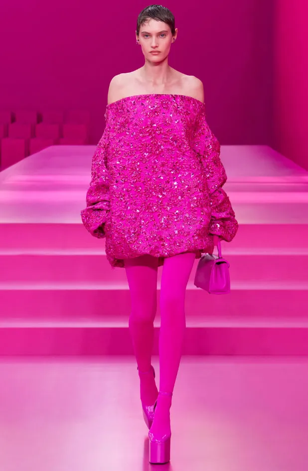 Valentino pembesi, omzu açık ve ışıltılı mini elbiseyle yürüyen modelin çarpıcı yılbaşı stili.