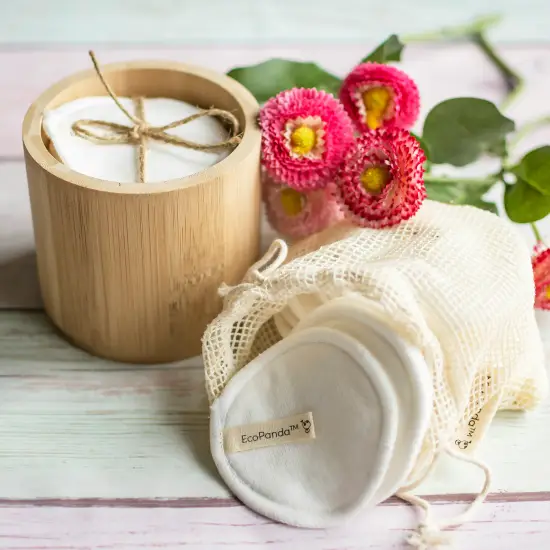 Evde spa rutini için kullanılan pamuk pedler, bambu kutu ve çiçeklerle hazırlanmış doğal bakım ürünleri.