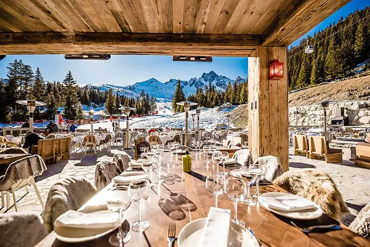 Courchevel kayak merkezinde pist manzaralı lüks restoran ve açık hava oturma alanı