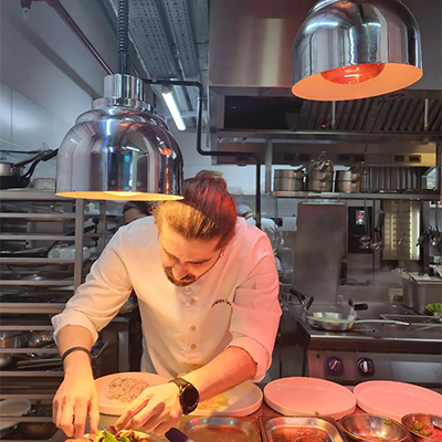 Beyaz şef ceketli ve saçları topuzlu Şef İbrahim Tunç, parlak paslanmaz çelik mutfakta tabakları titizlikle düzenlerken, tabağa son dokunuşları yaparak İstanbul'un Michelin Yıldızlı restoranları arasında adından söz ettiren Circle by Verticle'ın özel lezzetlerini sunuyor.