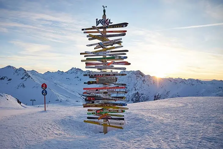 Avusturya Tirol bölgesindeki Ischgl kayak merkezinde yön tabelaları ve Alpler manzarası
