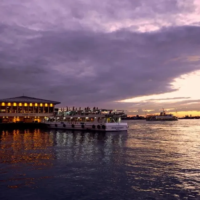 İstanbul'da gün batımında iskele ve denizde süzülen vapurlar, şehrin melankolik atmosferini yansıtan bir an.