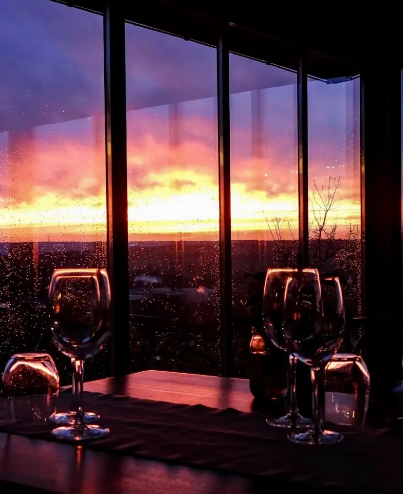 Bakucha Vineyard Hotel restoranında gün batımı manzarası ve şarap kadehleriyle romantik atmosfer
