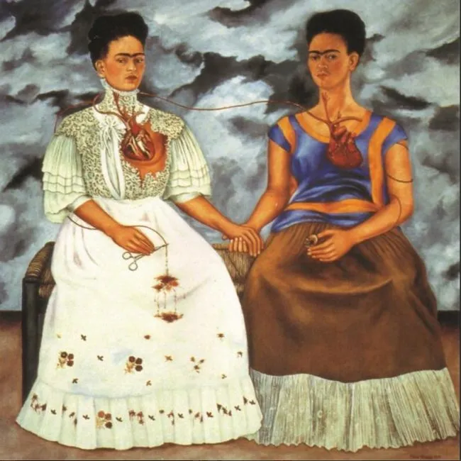 Frida Kahlo’nun 1939 tarihli “İki Frida” adlı eserinde, biri geleneksel Tehuana kıyafeti giymiş, diğeri Avrupa tarzı elbiseli iki Frida yan yana oturur. Açıkta kalan kalplerini bir damar birbirine bağlarken, ayrılık acısı, kimlik çatışması ve duygusal yıkım görsel olarak güçlü bir şekilde tasvir edilir.