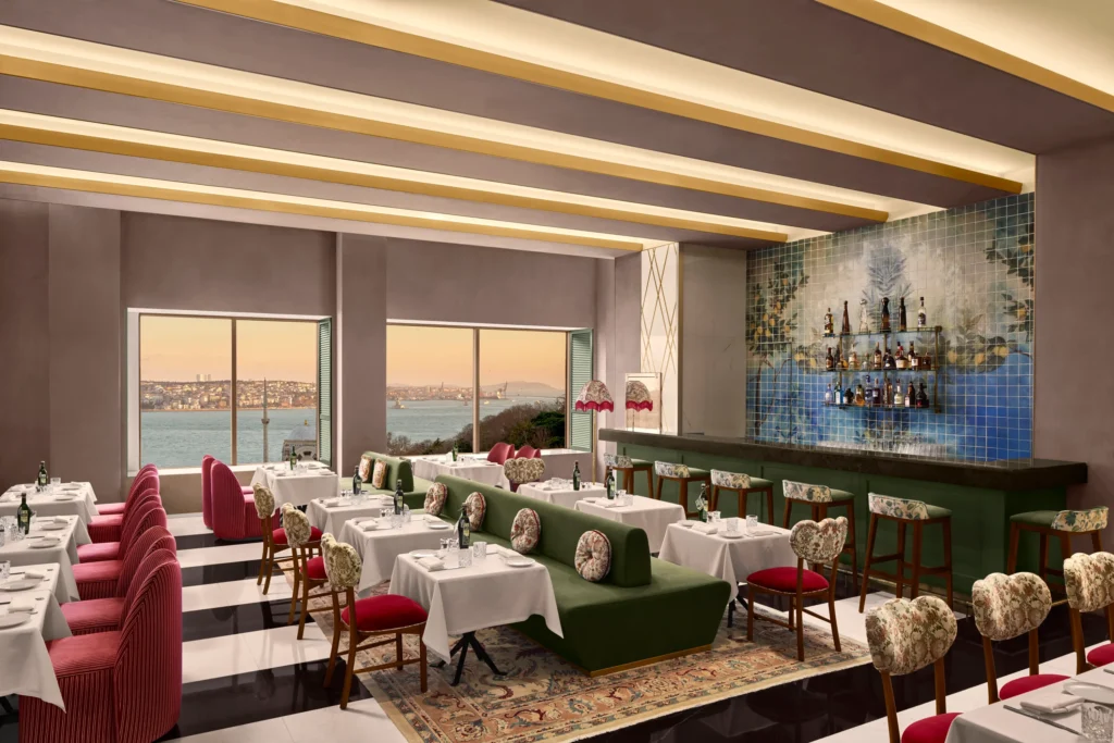 Limore restoranın pembe şeritli koltukları, yeşil kanepeleri, limon ağacı motifli fayans barı ve zarif dekorasyonuyla öne çıkan iç mekanından, Kız Kulesi'nin de görüldüğü büyüleyici İstanbul Boğazı manzarası eşliğinde günbatımı.