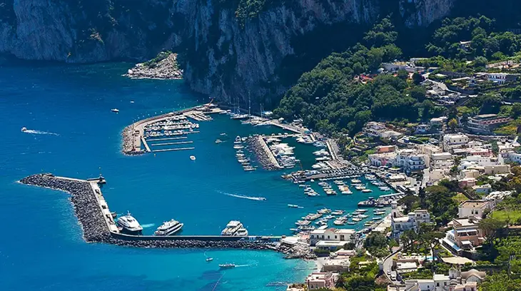 Capri Marina Grande’de pastel renkli evlerin süslediği lüks yat limanı ve turkuaz deniz manzarası