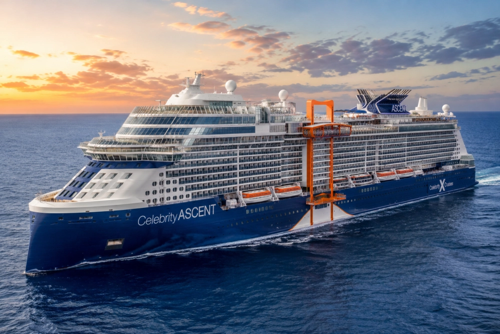Celebrity Ascent adlı modern cruise gemisi, masmavi denizde ilerlerken ufukta turuncu ve pembe tonlarındaki gün batımı ışıklarıyla aydınlanan gökyüzünün altında büyüleyici bir manzara sunuyor; unutulmaz bir ultra lüks cruise tatili deneyimi vadeden geminin kendine özgü turuncu platformu ve sayısız balkonu açıkça görülüyor.