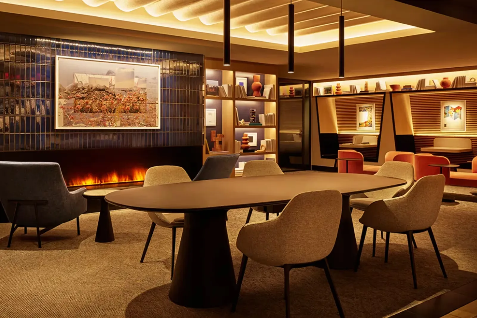 New York LaGuardia'daki Chase Sapphire havalimanı lounge'unun lüks atmosferinde, şöminenin önünde modern koltuklar, ortada oval bir masa ve arka planda kütüphane rafları ile turuncu dinlenme alanları, eşsiz bir seyahat konforu vadediyor.