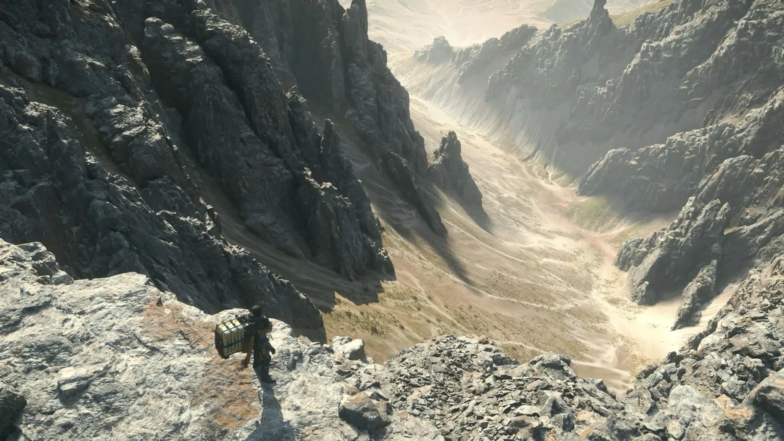Death Stranding 2 oyunundan bir sahne, geniş manzarada yalnız ilerleyen bir karakter