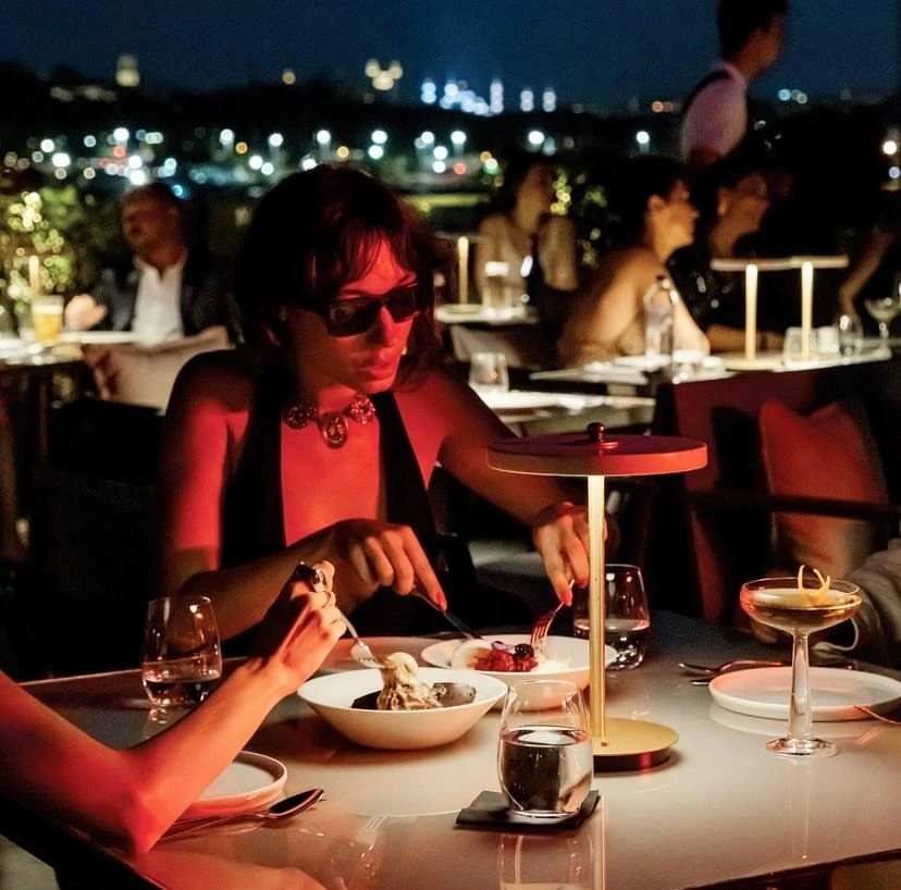 Frankie’de gece manzarası eşliğinde, loş ışıklar altında yemek keyfi yapan misafirler.
