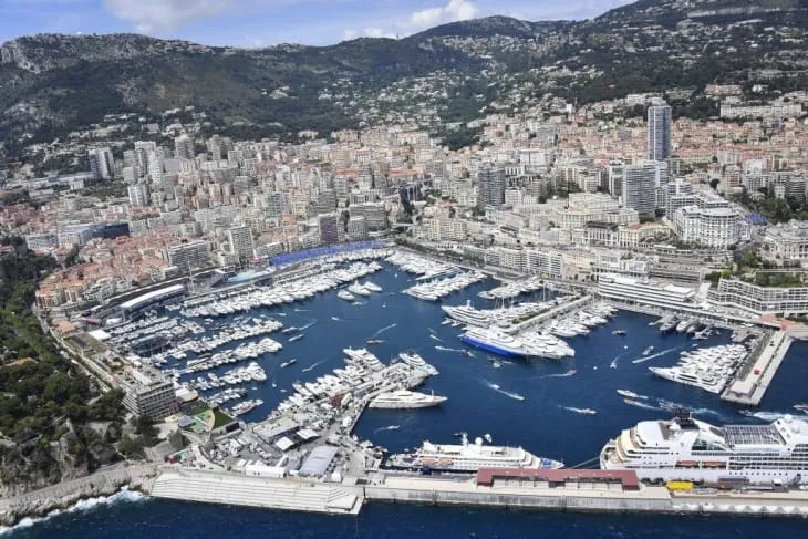 Port Hercule’de mega yatların sıralandığı marina ve arka planda Monako’nun ikonik şehir manzarası