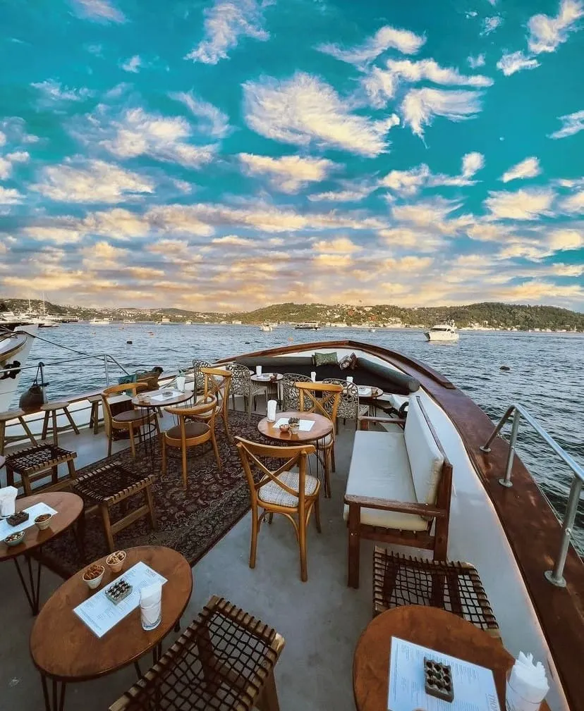 Thomas On the Shore’un üst güvertesinde Boğaz manzaralı masa düzeni ve rahat oturma alanları.