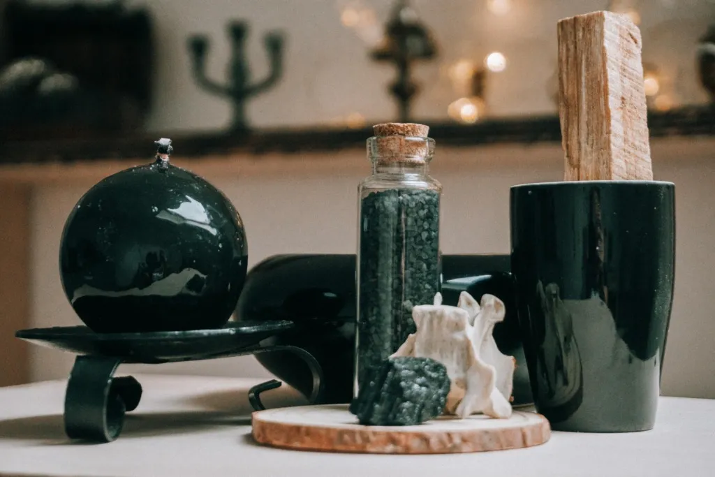 Siyah mum, Palo Santo, tuzlar ve kristallerle hazırlanmış spiritüel temalı masa düzeni.